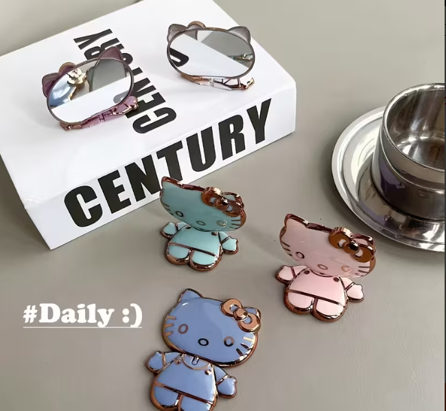Hello Kitty-shaped mobile phone holders/stands, with Mirror Folding which are designed to be attached to the back of a phone or tablet.